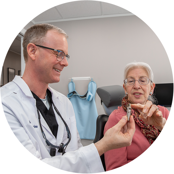 Doctor holding up dental implant